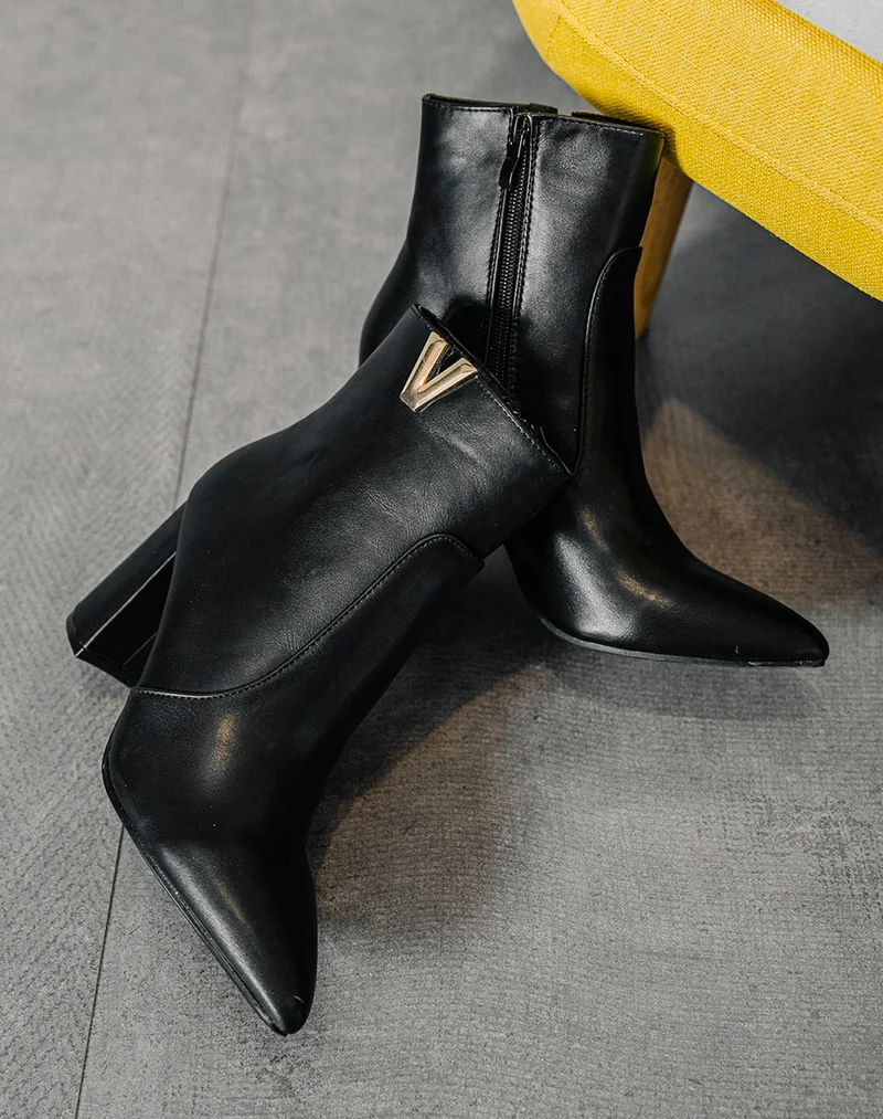 Bottines noires à détail doré en forme de v