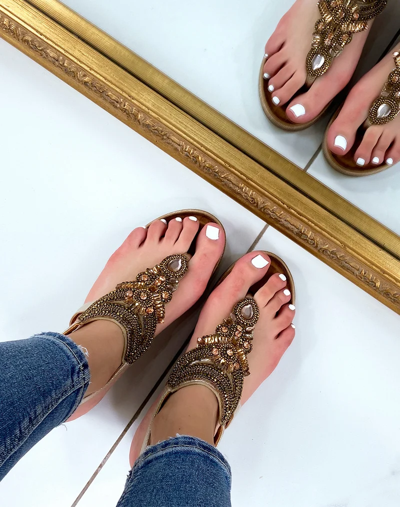 Nu-pieds dorées à entre-doigt orné de bijoux oranges roses et dorés