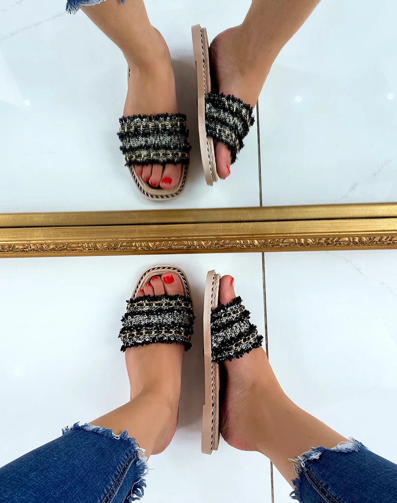 Mules plates noires à multiples détails et fine chaîne dorée