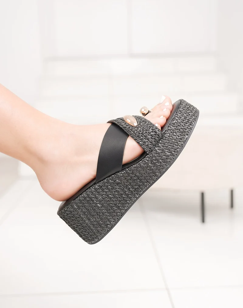 Mules noires compensées à plateforme avec lanière tissée et bijou doré